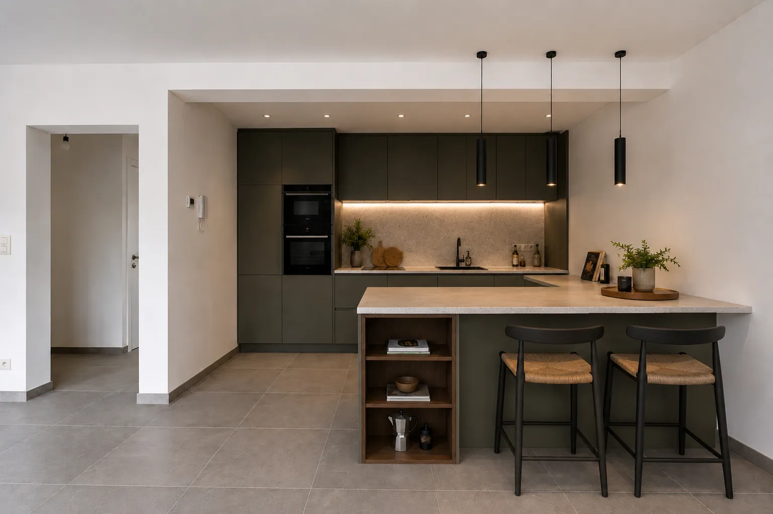 Impressie van de open keuken met olijfgroene kasten en ontbijtbar met barkrukken
