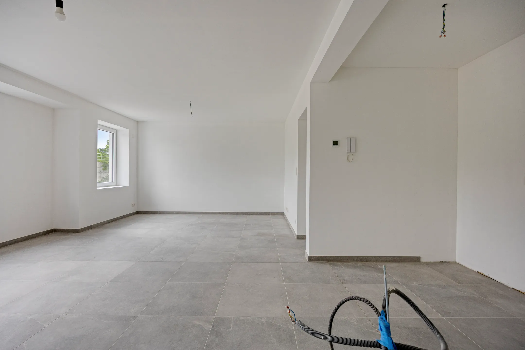 Open leefruimte met raam en parlofoon