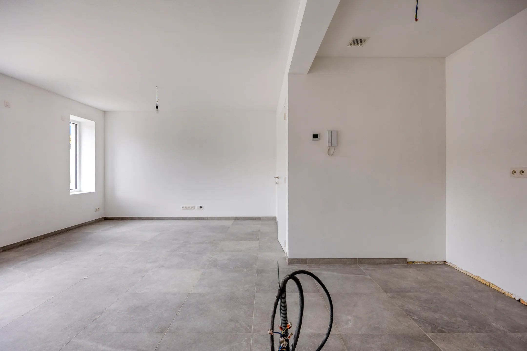 Woonkamer met raam en parlofoon
