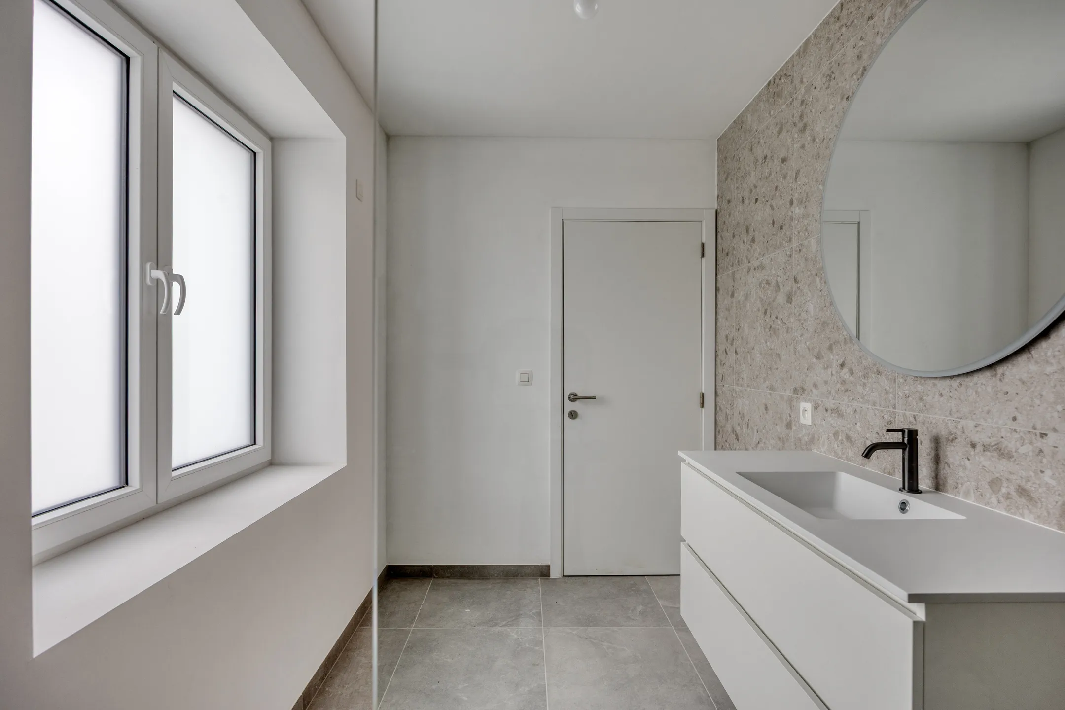 Badkamer met meubel, spiegel en matglas ramen