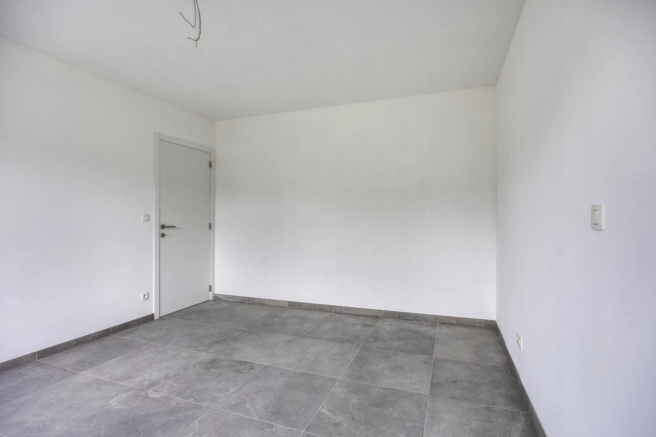 Slaapkamer met grijze tegelvloer
