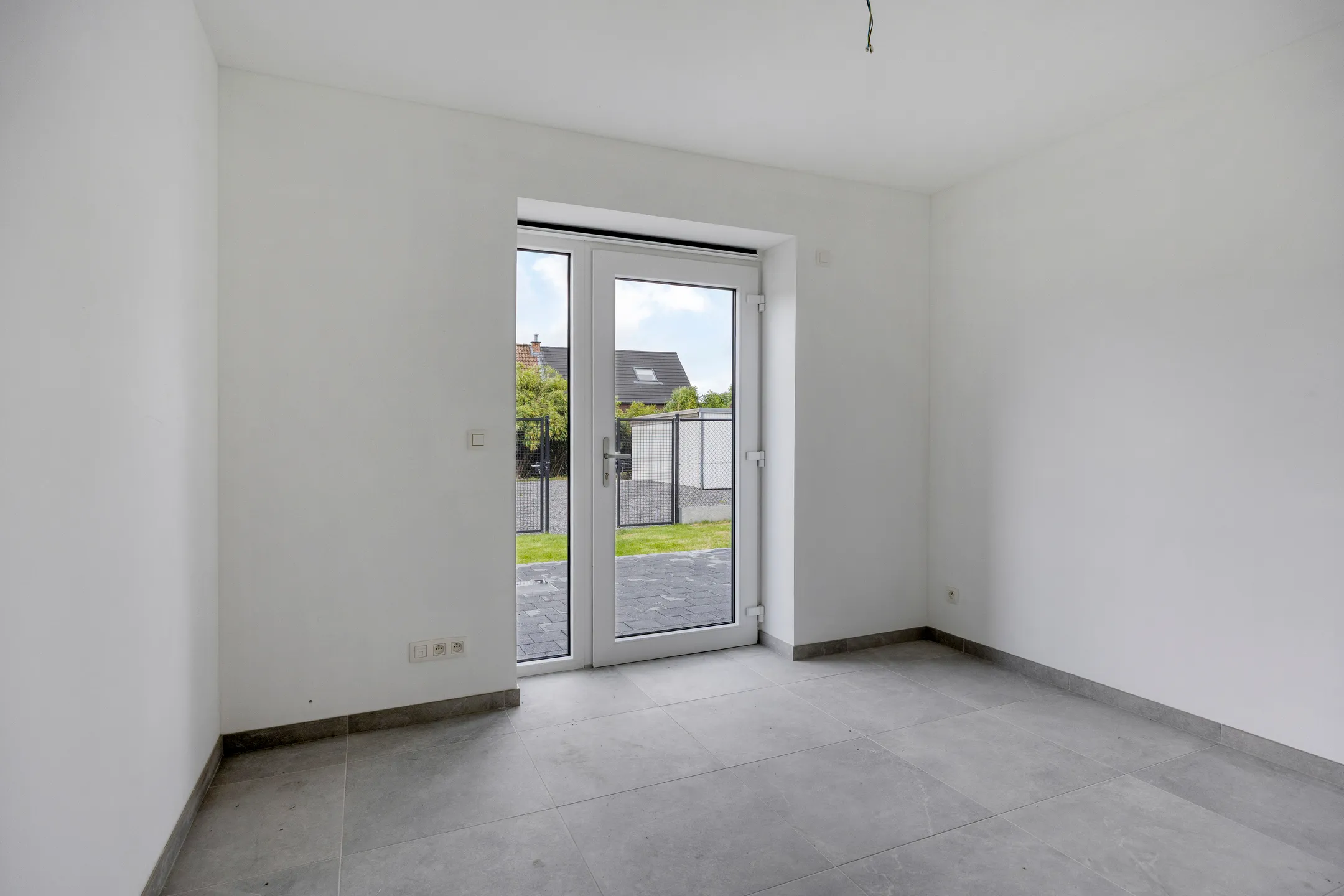 Slaapkamer met glazen terrasdeur naar de tuin
