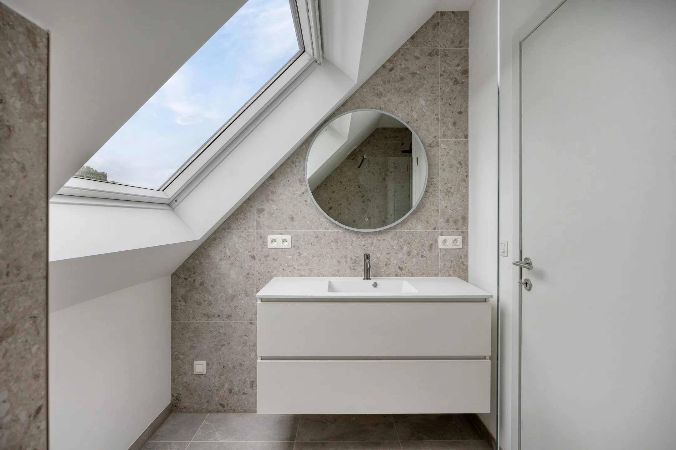 Badkamer met meubel, spiegel en dakraam