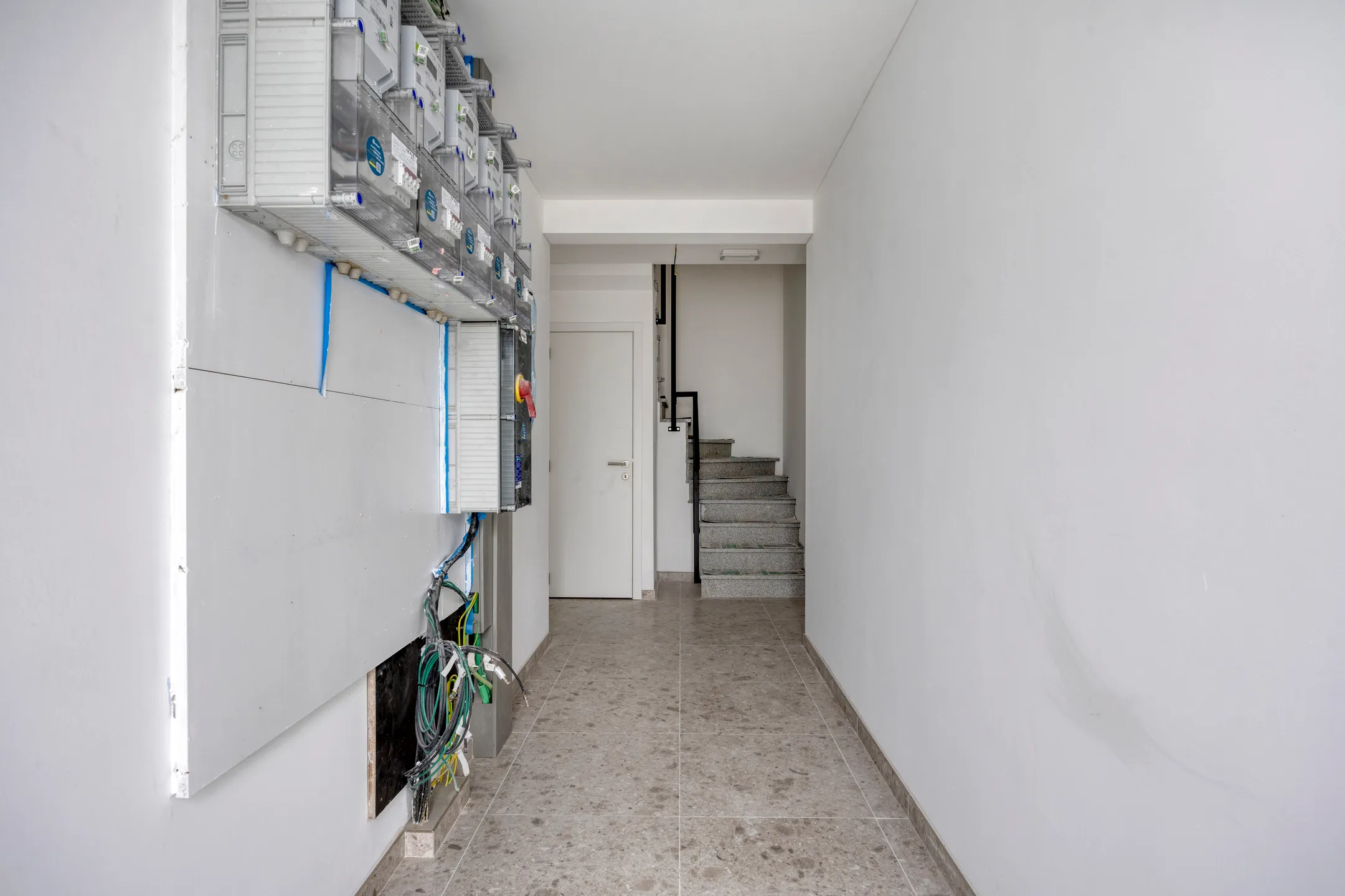 Gemeenschappelijke inkomhal met meterkasten en trap